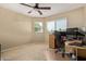 Bright bedroom with a ceiling fan, carpet and a window with blinds, plus a corner workstation at 4514 E Verbena Dr, Phoenix, AZ 85044
