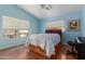 Bright bedroom with wood floors, a white ceiling fan, and a view of the outside at 4514 E Verbena Dr, Phoenix, AZ 85044