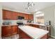 Well-lit kitchen with stainless steel appliances, wooden cabinets and an island with white countertop at 4514 E Verbena Dr, Phoenix, AZ 85044