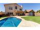 Inviting backyard oasis featuring a sparkling pool, lush lawn, and covered patio at 4514 E Verbena Dr, Phoenix, AZ 85044