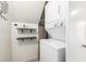 Cozy laundry room featuring a stackable washer and dryer and convenient shelving for storage and modern smart lock at 4901 E Kelton Ln # 1251, Scottsdale, AZ 85254