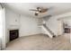 Bright living room with a fireplace, ceiling fan, wood floors, and a staircase at 4901 E Kelton Ln # 1251, Scottsdale, AZ 85254