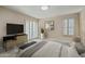 Cozy bedroom featuring neutral tones, plantation shutters, bench, and a TV entertainment center at 5998 N 78Th St # 116, Scottsdale, AZ 85250