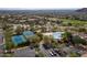 Aerial view showcasing community pool, tennis courts, parking, and numerous houses nestled among lush greenery at 7261 E Norland St, Mesa, AZ 85207