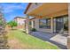 Well-maintained backyard with green lawn, a tree and covered patio at 7261 E Norland St, Mesa, AZ 85207