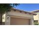 Attached garage with a decorative tile roof and exterior coach lights at 7261 E Norland St, Mesa, AZ 85207