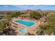 Aerial view of community pool with mature landscaping and desert mountain views in the distance at 7261 E Norland St, Mesa, AZ 85207