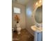 Cozy powder room featuring a pedestal sink and tiled floors, with a decorative mirror at 7321 S 48Th Dr, Laveen, AZ 85339