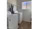 Functional laundry room featuring modern appliances, shelving, and a window for natural light at 7321 S 48Th Dr, Laveen, AZ 85339