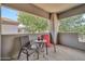 Relaxing balcony features two chairs, a table, and views of the neighborhood greenery at 7401 W Arrowhead Club Dr # 2067, Glendale, AZ 85308