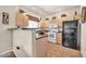 Efficient kitchen featuring light wood cabinets, black appliances, and tile flooring at 7401 W Arrowhead Club Dr # 2067, Glendale, AZ 85308