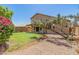 Spacious backyard featuring a lush lawn, mature trees, decorative rock, and a covered patio at 8478 W Grovers Ave, Peoria, AZ 85382