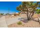 Home boasts mature shade trees, desert landscaping, and a spacious driveway leading to a two-car garage at 8478 W Grovers Ave, Peoria, AZ 85382