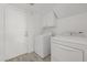 Bright laundry room featuring a full-size white washer and dryer set with storage cabinets at 8478 W Grovers Ave, Peoria, AZ 85382