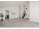 Spacious living room with gray-tone tile flooring and view into the kitchen and staircase at 8478 W Grovers Ave, Peoria, AZ 85382