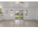 Open living room with tiled floors and sliding glass door to an outdoor view at 8478 W Grovers Ave, Peoria, AZ 85382