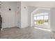 Open-concept living space features tile floors, high ceilings, and a large window for natural light at 8478 W Grovers Ave, Peoria, AZ 85382