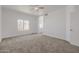 Spacious bedroom with neutral carpet, ceiling fan, and natural light at 8478 W Grovers Ave, Peoria, AZ 85382