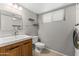 Bathroom and laundry area combination with wooden vanity and modern appliances at 8876 W Bluefield Ave, Peoria, AZ 85382