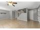 Neutral living room featuring tile floors, stairway, ceiling fan, and access to other rooms at 8876 W Bluefield Ave, Peoria, AZ 85382