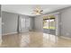A view of the living room with tile floors, a ceiling fan, and a sliding glass door to the backyard at 8876 W Bluefield Ave, Peoria, AZ 85382