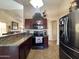 Well-equipped kitchen with granite countertops, dark wood cabinets, and stainless steel appliances at 8908 W Sheridan St, Phoenix, AZ 85037