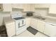 Cozy kitchen featuring a range, stainless steel sink, and white cabinets at 9726 E Quarterline Rd, Mesa, AZ 85207