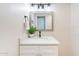 Bathroom vanity featuring framed mirror, potted plant, and ample lighting at 1061 E Fremont Dr, Tempe, AZ 85282