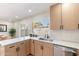 Well-lit kitchen featuring quartz countertops, stainless steel sink, and a large window overlooking the backyard at 1061 E Fremont Dr, Tempe, AZ 85282