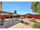 Backyard featuring a pool with a water feature, lush landscaping, and covered patio seating at 10786 W Chisholm Dr, Sun City, AZ 85373