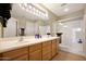 Bathroom featuring double sinks, vanity with cabinets, large mirrors and a walk-in shower at 10786 W Chisholm Dr, Sun City, AZ 85373