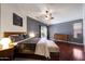 Spacious bedroom boasts dark hardwood floors, a modern color scheme, a ceiling fan, and a slider to the backyard at 10786 W Chisholm Dr, Sun City, AZ 85373