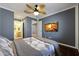 Comfortable bedroom features dark hardwood floors, neutral tones, a ceiling fan, and modern entertainment center at 10786 W Chisholm Dr, Sun City, AZ 85373