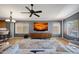 Open living room featuring a ceiling fan and a large media center with modern decor and a gray accent wall at 10786 W Chisholm Dr, Sun City, AZ 85373