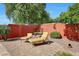 Charming brick patio with lounge chairs, mature trees, and a painted privacy wall, creating a relaxing outdoor space at 10786 W Chisholm Dr, Sun City, AZ 85373