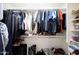 Organized walk-in closet with hanging clothes, shelves, and floor storage for shoes and luggage at 10786 W Chisholm Dr, Sun City, AZ 85373
