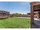 Backyard featuring artificial turf, brick pavers, and residential surroundings at 10827 W Bronco Trl, Peoria, AZ 85383