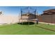 Backyard showcasing green artificial turf and a trampoline at 10827 W Bronco Trl, Peoria, AZ 85383