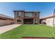 Spacious backyard with green artificial turf and exterior view of the house at 10827 W Bronco Trl, Peoria, AZ 85383