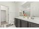 Clean bathroom with a gray vanity, large mirror, and a shower-tub combo at 10827 W Bronco Trl, Peoria, AZ 85383