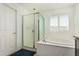 Bright bathroom featuring a shower and tub with a window at 10827 W Bronco Trl, Peoria, AZ 85383