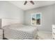 Bright bedroom featuring a ceiling fan, white shuttered window, and tiled floors at 10827 W Bronco Trl, Peoria, AZ 85383
