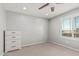Bedroom featuring ceiling fan, window with shutters, and a dresser at 10827 W Bronco Trl, Peoria, AZ 85383
