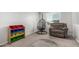 Relaxing flex room with an egg chair, recliner, and colorful toy storage at 10827 W Bronco Trl, Peoria, AZ 85383