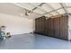 Spacious garage with epoxy floor and built-in dark wood cabinets for ample storage at 10827 W Bronco Trl, Peoria, AZ 85383