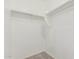 Efficient walk-in closet with simple shelving and carpeted floor at 10827 W Bronco Trl, Peoria, AZ 85383