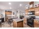 Open eat-in kitchen offers wood cabinets, an island, and view to living room at 10951 N 91St Ave # 84, Peoria, AZ 85345