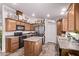 Spacious kitchen with a central island, wood cabinets, and modern black appliances at 10951 N 91St Ave # 84, Peoria, AZ 85345