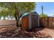 The large storage shed is shaded by a large tree in this backyard at 10951 N 91St Ave # 84, Peoria, AZ 85345