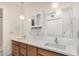 Bright bathroom featuring double sinks, a large mirror, modern lighting, and vanity storage at 11238 N 11Th St, Phoenix, AZ 85020